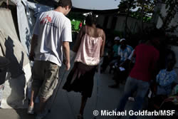 地震によって外傷を負い、片足を切断した女性に付き添うMSFの理学療法士。2010年2月、ハイチ。
