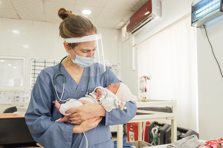 モスル西部ナブルス地区にあるMSF病院で生まれた赤ちゃんを抱く小児科医　© Peter Bräunig