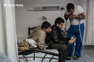 スマートフォンでゲームを楽しむシリア人とイラン人の患者たち(2016年3月撮影)
