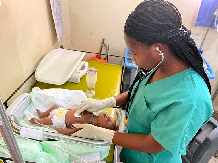 A nurse simulating the process of neonatal care using the prototype and a doll. © MSF
