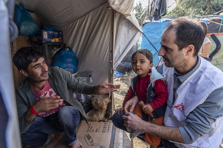 ギリシャ・レスボス島で難民の家族と話すクリストゥ会長　© Anna Pantelia/MSF