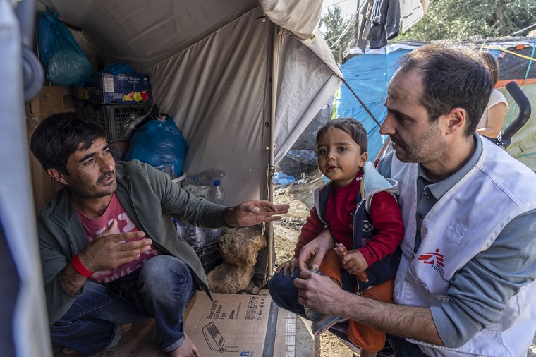 ギリシャ・レスボス島で難民の家族と話すクリストゥ会長 © Anna Pantelia/MSF