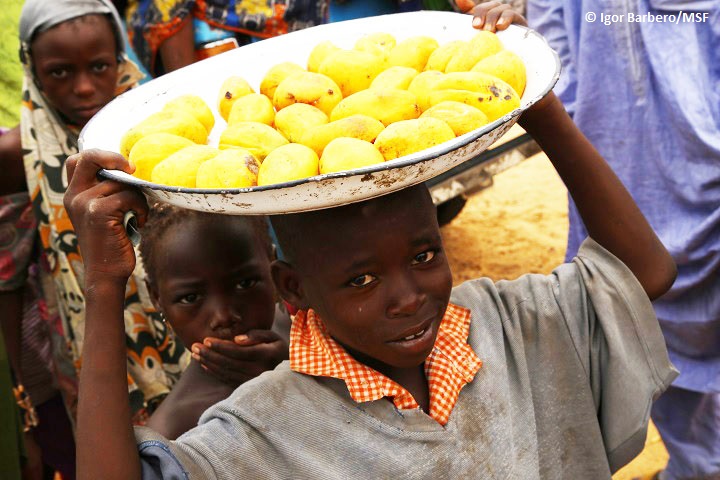 ナイジェリア北東部ボルノ州の国内避難民キャンプで果物を運ぶ男の子