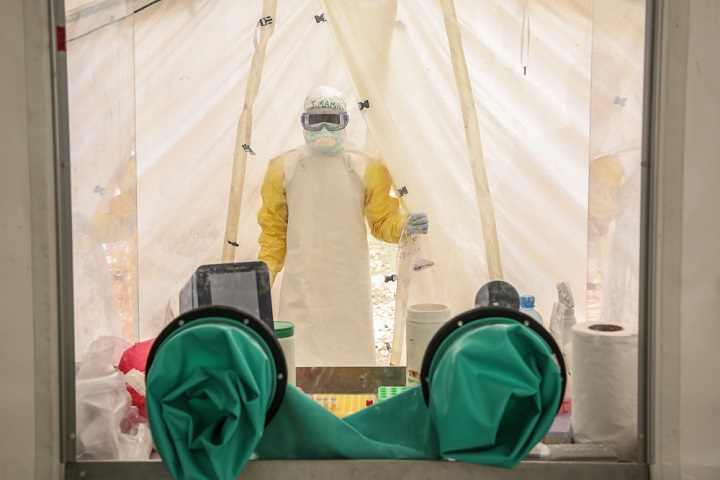 血液サンプルを手に検査室へ入るMSF看護師。エボラ治療センターに検査室を併設するのは今回が初めて© Carl Theunis/MSF