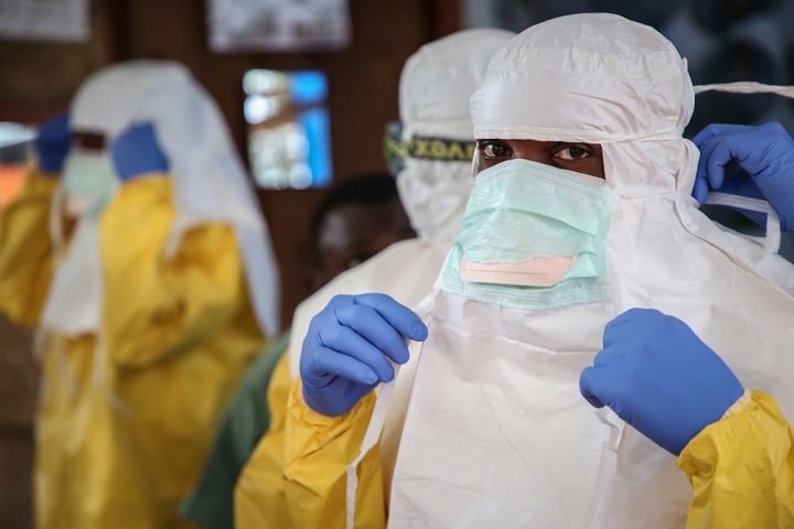 病棟へ向かう前に防護服を着用する医療スタッフ © Carl Theunis/MSF