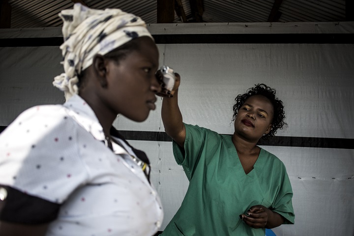MSFが支援する病院で、病院内へ入る前に体温をチェックする来院者　© John Wessels