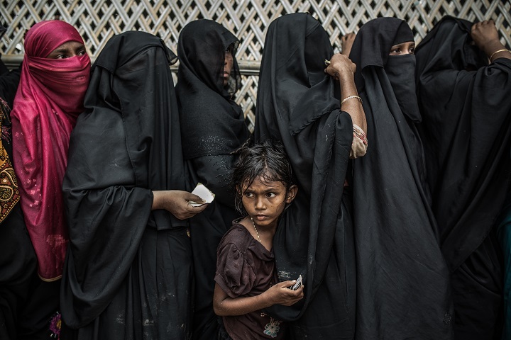 雨の中で食料配給を待つロヒンギャの少女。バングラデシュ・コックスバザール、ジャムトリ仮設難民キャンプ（2018年7月）
© Pablo Tosco/Angular