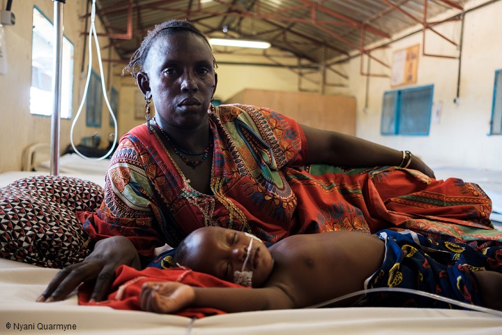 急性マラリアにかかった息子モハマドちゃん（1歳2ヵ月）を連れ、MSF病院の小児病棟を訪れたファディマタさん。「もっと近い場所にも病院はありますが、MSFは質の高い治療が受けられるので、遠く離れていてもここに来ます。息子はよくなっています」