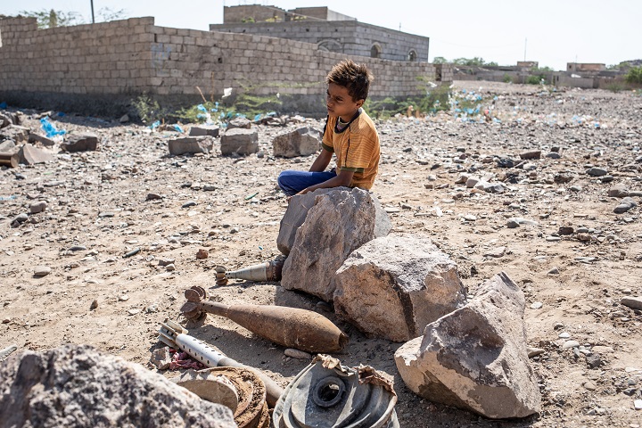 イエメン南西部、タイズ県モウザで除去された地雷やロケット弾を見つめる少年　© Agnes Varraine-Leca/MSF