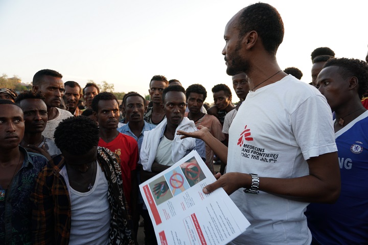MSFの健康教育担当者が、ヘビにかまれたときの危険や予防を出稼ぎ労働者に説明する　© Susanne Doettling/MSF