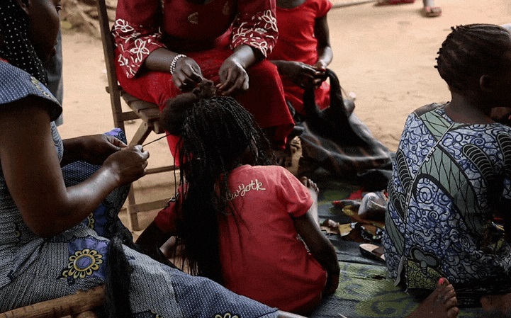 元子ども兵士だった女の子の髪を結う女性たち。© Alex McBride/MSF