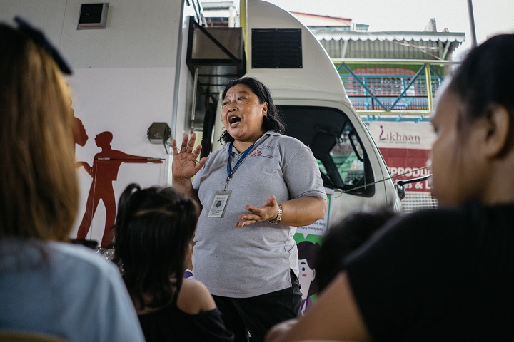 トンドの人びとに家族計画の重要性やケアの必要性を説明するスタッフ　© Hannah Reyes Morales