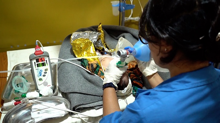 手動のバルブバッグマスクで赤ちゃんの呼吸を助ける看護師　© Nitin George/MSF