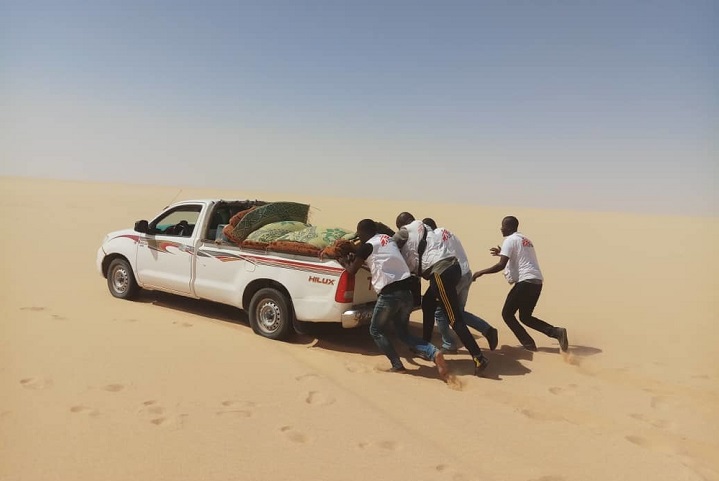 砂漠にはまったMSF車両を押すスタッフ © Innocent Kunywana/MSF