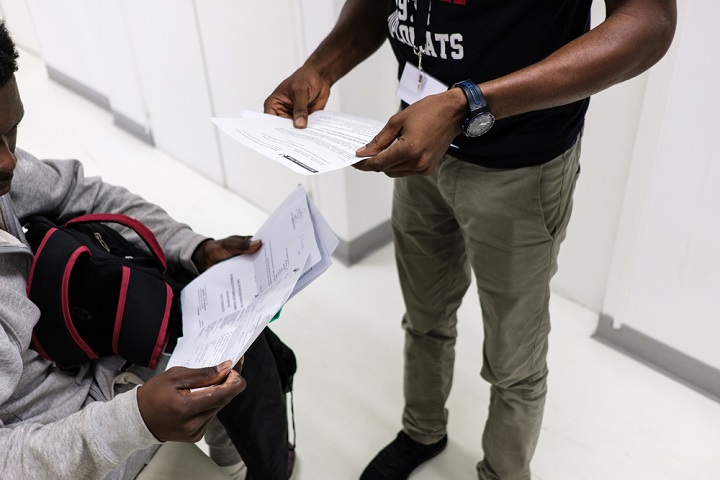 行政手続きの用紙を手にする難民の若者（左）© Augustin Le Gall