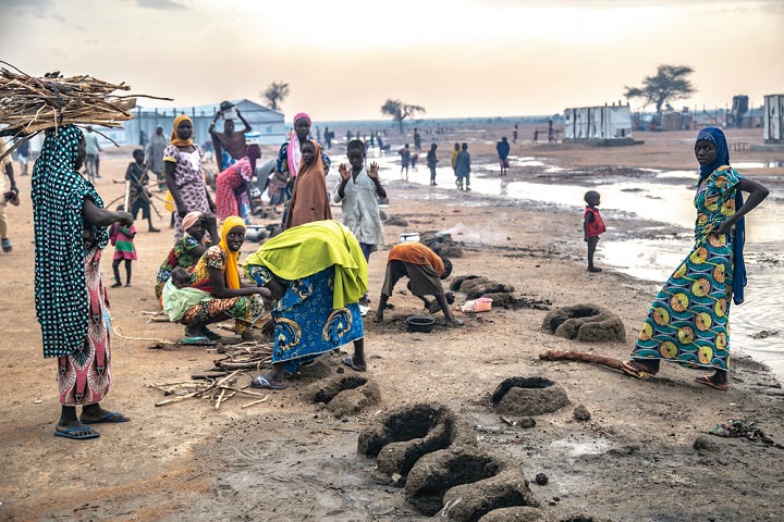 屋外で夕食の準備をするプルカで避難生活を送る女性たち © Igor Barbero/MSF