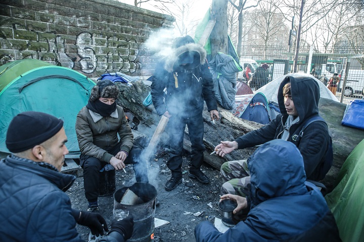 パリ郊外にて、移民の人びとが焚火で寒さをしのいでいる光景　© Mohammad Ghannam/MSF