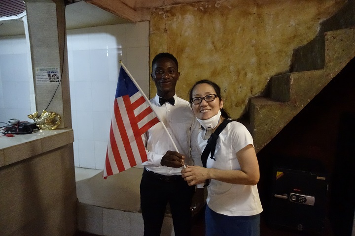 MSF名取とリオ・ノニさん。リベリアの国旗を持って 　ⓒ Toru Hanai/MSF