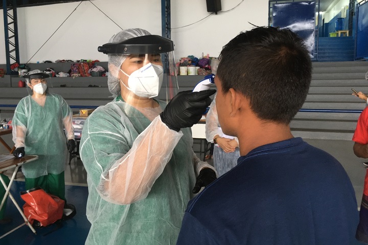 ブラジルのシェルターで暮らす人びとに感染の疑いがないか確認するMSFの看護師　© MSF