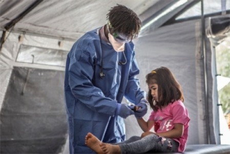 ギリシャのレスボス島でコロナの症状を訴える難民の子どもを診察する国境なき医師団の医師　© Anna Pantelia/MSF