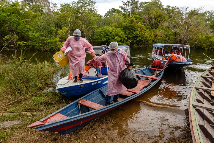 ミリニ河畔の居住地に到着したMSFと地元の保健局のスタッフ。ボートを降りて、訪問診療で定例の検診と予防接種を行う　© DiegoBaravelli/MSF
