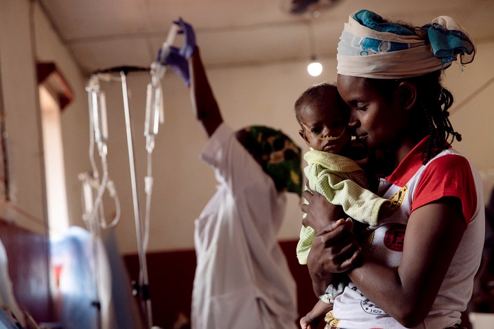 心臓に疾患のある娘を抱く母親　国内での治療は難しい状況だ　© Adrienne Surprenant / Collectif/MSF