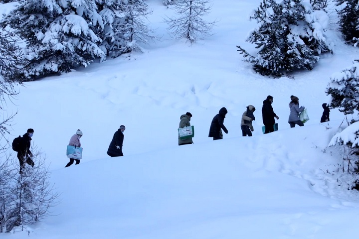 イタリア北部からフランスを目指し、雪山を歩くアフガニスタン人の一家　© Francesca Volpi