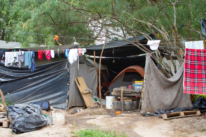 難民申請の審査を待つ移民たちが暮らすテント。ビニール袋や古い毛布などを使って雨風を防いでいる　🄫 MSF/Arlette Blanco