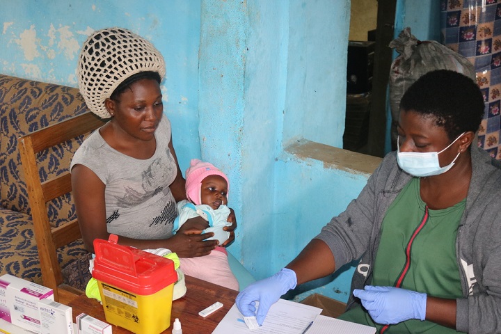 南西部の村でマラリアの症状がある赤ちゃんの相談を受ける保健ボランティア　© Fanwi Antoinette Buinda/MSF