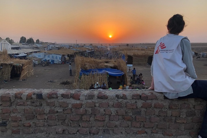 ハムダイェトの町を眺めるMSFスタッフ　人びとはキャンプへ送られるまでの日々をここで過ごす　© MSF