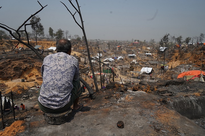 3月22日に発生した大規模火災の焼け跡を見つめるロヒンギャの男性 🄫 Pau Miranda