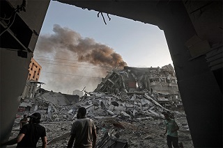 煙が上がる建物を見つめる人びと<br> 🄫 Mohammed ABED / AFP