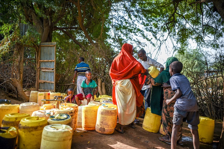 キャンプの給水所で水を汲む人びと。難民だけでなく、元から住んでいた地域住民も支援を受けている　© Paul Odongo/MSF