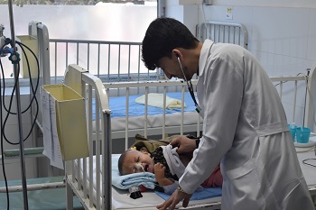 ヘラート州の入院栄養治療センターで赤ちゃんを
診察する医師=2020年　© Waseem Muhammadi/MSF