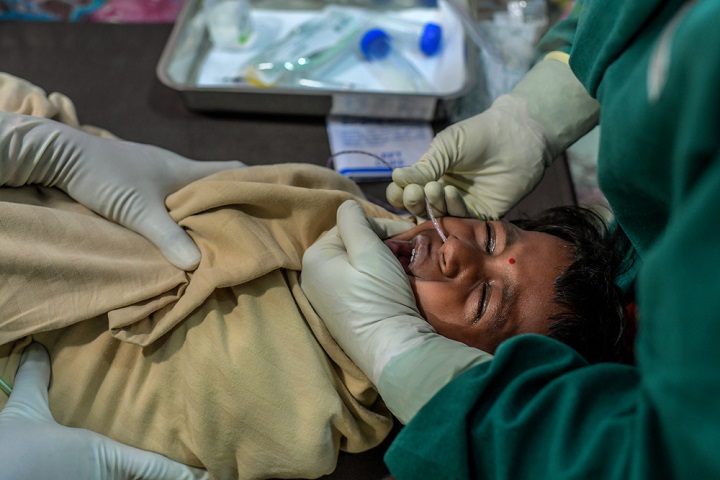 結核の診断のため、鼻からチューブを挿入するMSF看護師 © Atul Loke