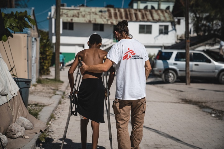 地震で負傷し、理学療法を受ける男性を支えるMSFの医師　© Pierre Fromentin/MSF