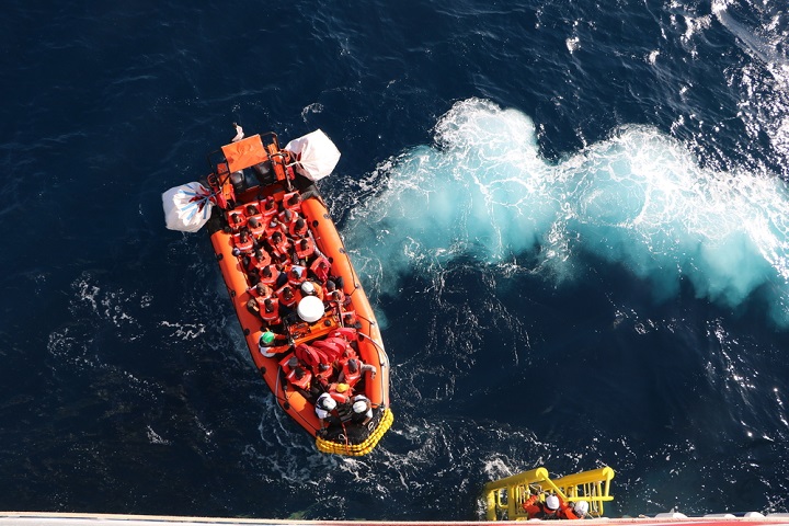遭難した船から救助され、ボートに乗る人びと。2021年12月22日は一隻の船から82人を救助した　 © Eloise Liddy/MSF