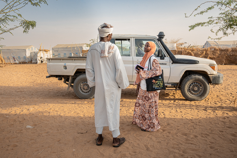 ウレ・カッソーニ難民キャンプ内の、ある区画の住民を束ねるリーダー（左）と話す国境なき医師団（MSF）のヘルスプロモーター、サーディア・ユースフ・アブドッラー＝チャドで2026年7月24日　© Flurina Rothenberger/MSF