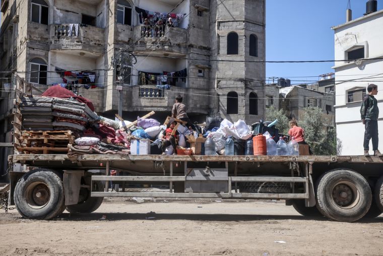イスラエル軍の退避要求を受け、ガザ南部ラファから荷物とともに逃れる人びと © MSF