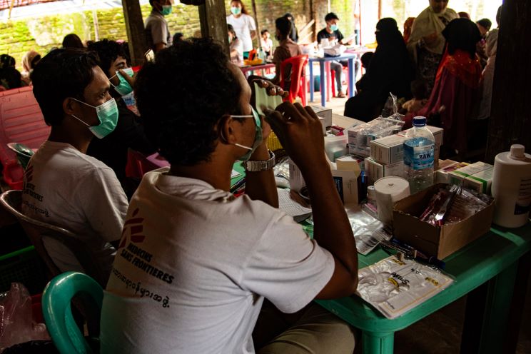 ラカイン州で2023年、移動診療を行って患者に薬を渡すMSFスタッフら © Zoe Bennell/MSF