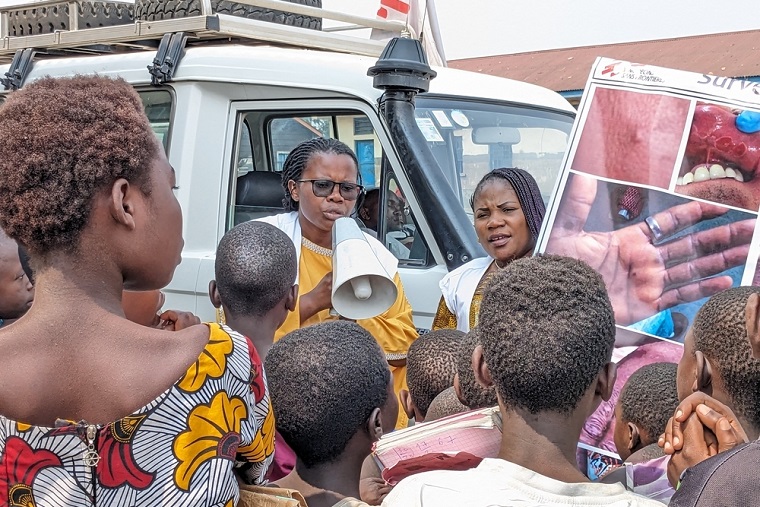 住民に向けてエムポックスの啓発活動に取り組むMSFスタッフ © MSF