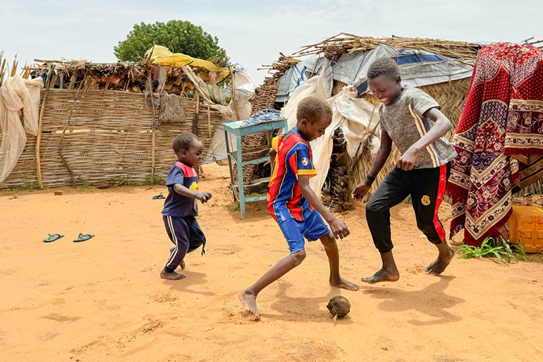 靴下にビニールを詰めて作ったボールで、弟とサッカーをするマジムさん(右) Ⓒ Thibault Fendler/MSF
