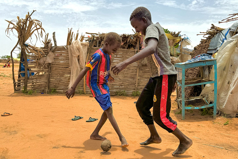 弟とサッカーをするマジムさん(右)。ボールは靴下にビニールを詰めて作った Ⓒ Thibault Fendler/MSF