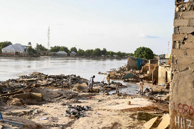 洪水で破壊された家屋の残骸と人びと=2024年9月18日 Ⓒ Abba Adamu Musa/MSF