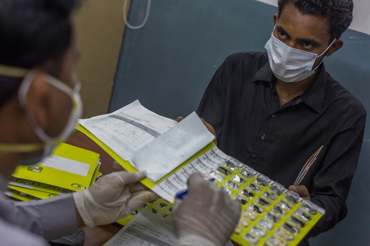 endTB-Q試験に参加しているパキスタンの患者のため、IRDが運営する診療所で新しい薬の説明を受ける介助者の男性 © Asim Hafeez