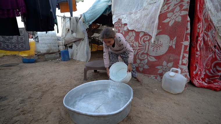 家族の衣服を洗うため、毎日水を汲みに行く11歳の少女 © Ibrahim Nofal
