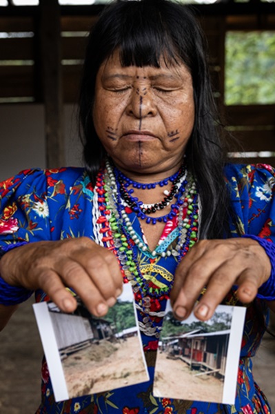 現地の女性ヒーラーであるロジェリーナさんが「治癒すべき地」の写真を裂いているところ。彼女は、人びとを治癒するのと同じように、草と糸で写真を縫合していく(動画参照) © Fernanda Pineda/MSF