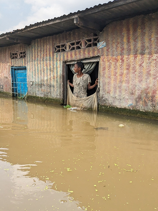 コンゴ民主共和国：キンシャサ州リメテ区のキンガブワ地区に住むジュリエンヌさん。玄関の前で、カヌーで学校に行った子どもたちを待つ。この地域は何年も洪水被害に見舞われている＝2024年1月18日　Ⓒ  Marion Molinari/MSF