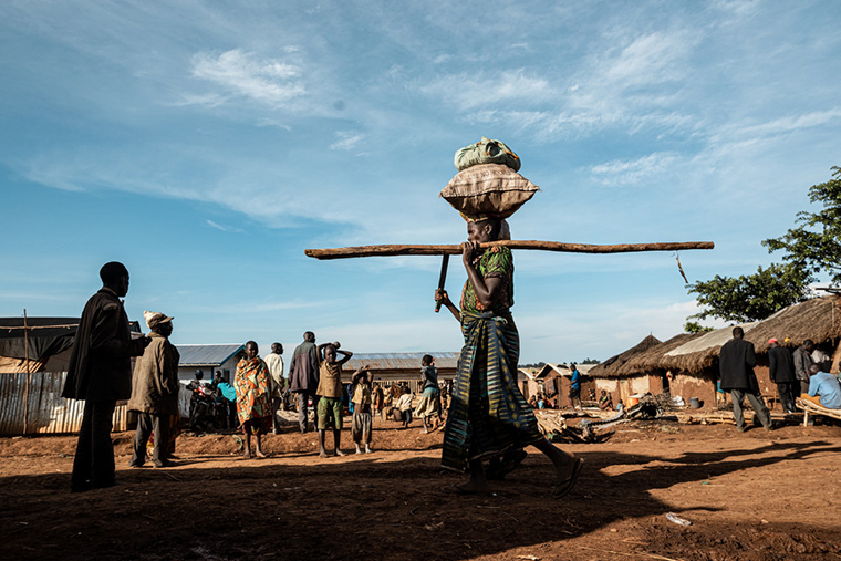 頭上に食料を乗せ、ロー国内避難民キャンプに戻ってきた女性　Ⓒ Michel Lunanga/MSF