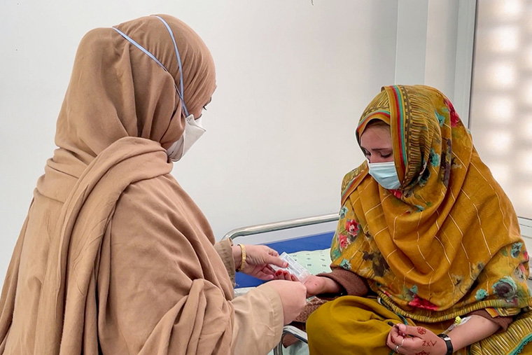 治療を受けるザイナブさん（右）とMSFの看護師　Ⓒ Noor Ahmad Saleem/MSF 